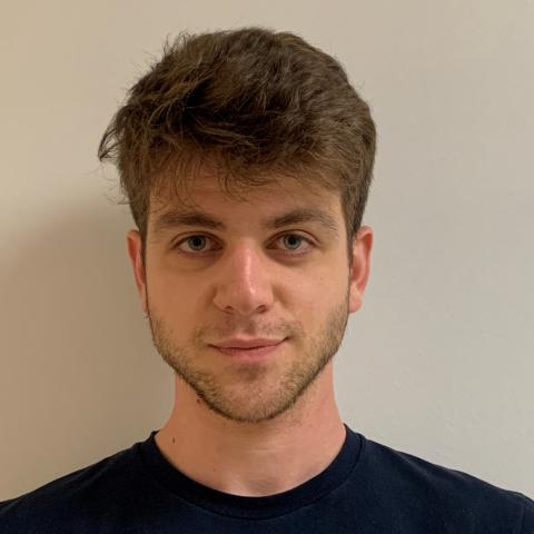 Headshot of a man against a blank wall