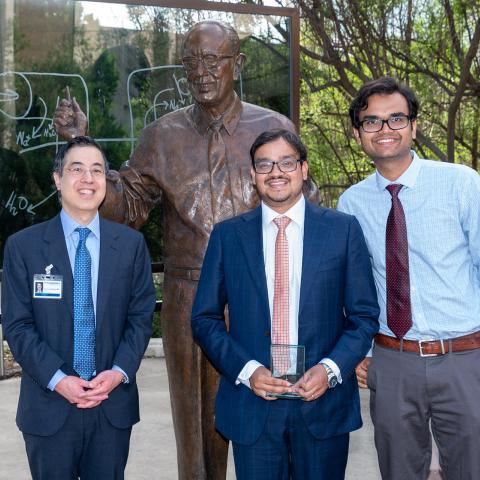 Dr. Thomas J. Wang, Dr. Sumitabh Singh and Dr. Abmarish Pandey standing infront of a statue of Dr. Donald Seldin