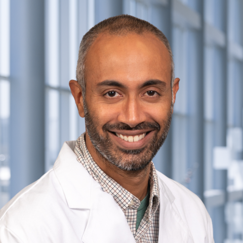 a man with short hair, beard and mustache wearing a white lab coat