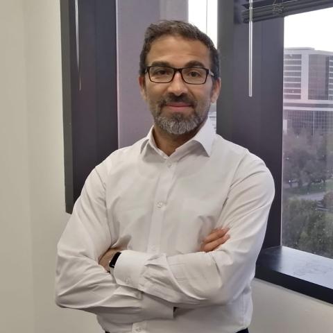 a man with a beard wearing glasses and a white lab coat